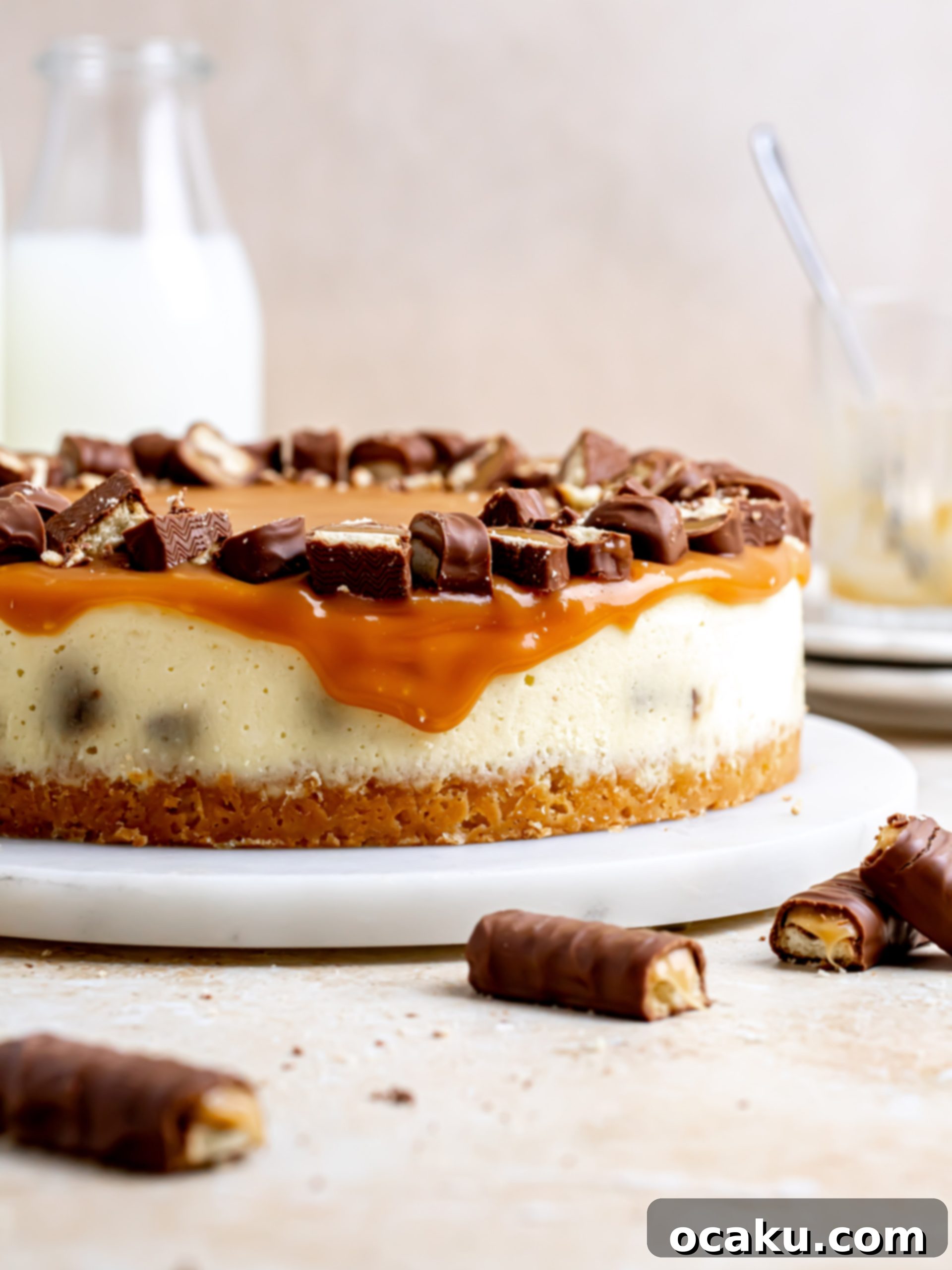 Twix Caramel Cheesecake 3 Close-up of a Twix Cheesecake, highlighting the rich caramel topping and visible pieces of Twix candy.