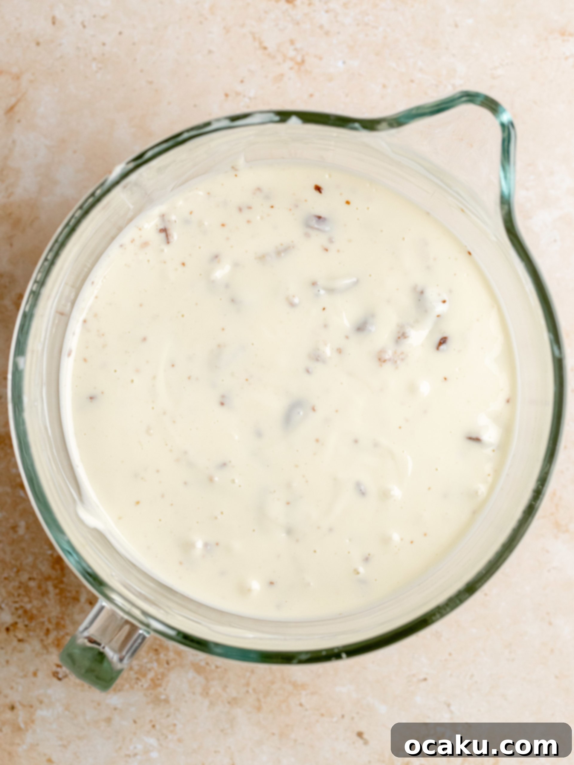 Twix Caramel Cheesecake 8 Step-by-step image showing sour cream and cornstarch being mixed into the cheesecake batter.