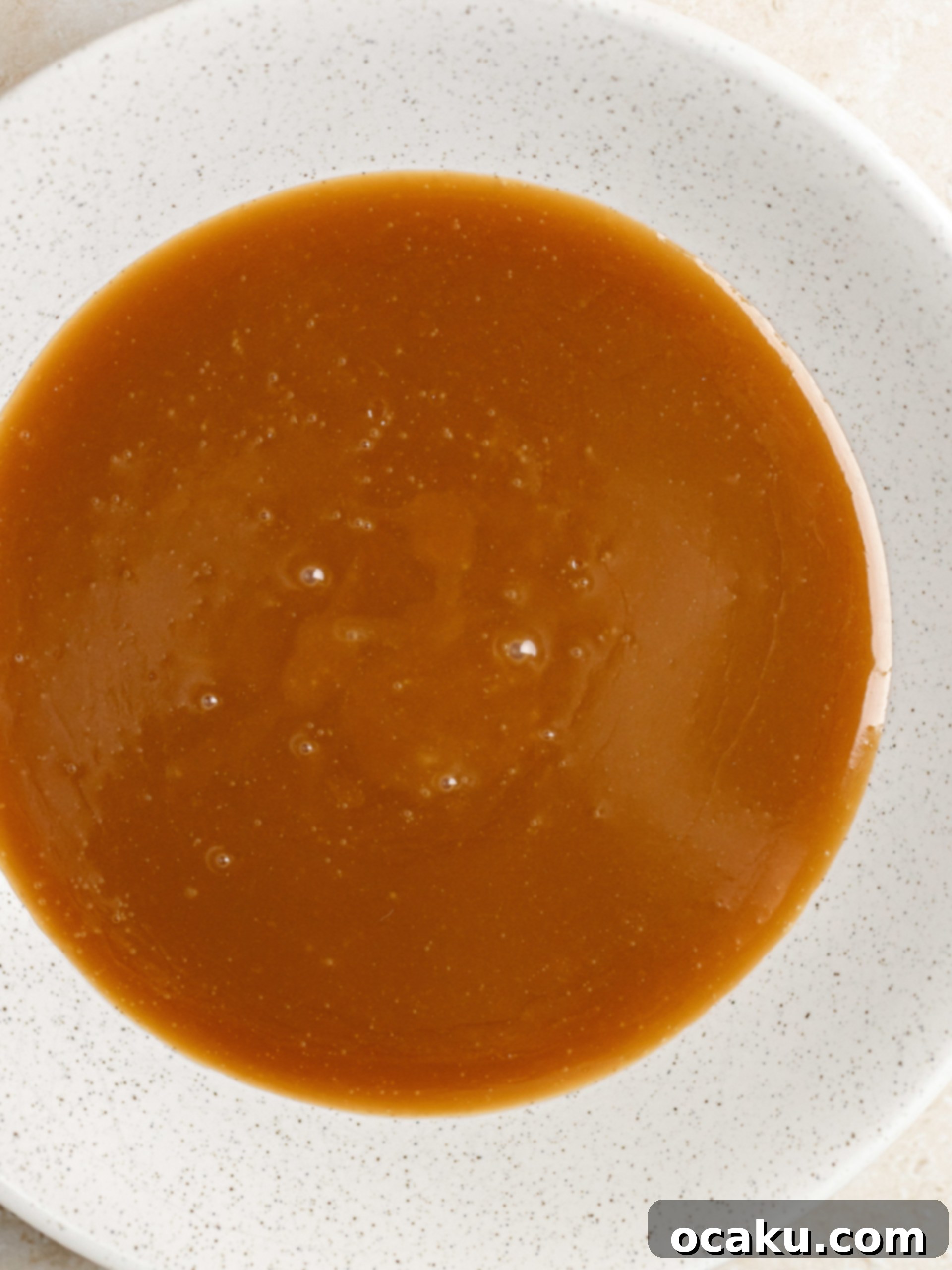 Twix Caramel Cheesecake 10 Step-by-step image showing granulated sugar and corn syrup melting in a saucepan for caramel.