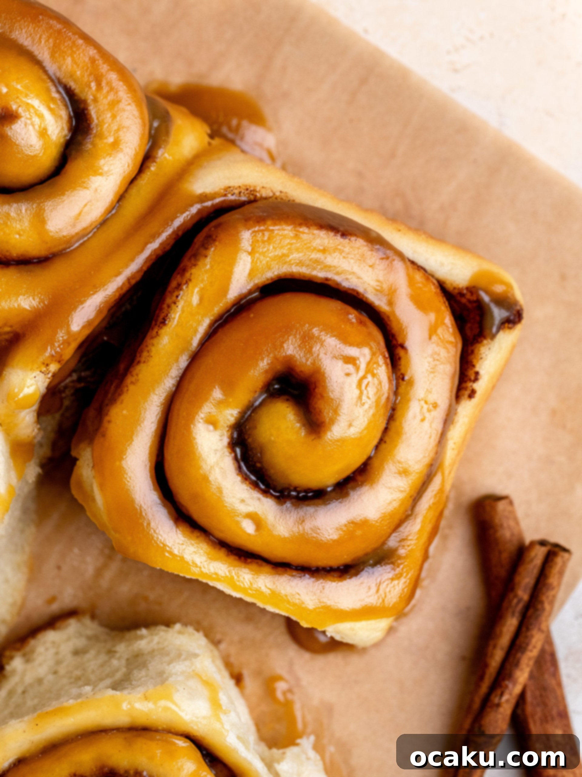 Close-up of unbaked caramel cinnamon rolls arranged in a baking dish, ready for their second rise.
