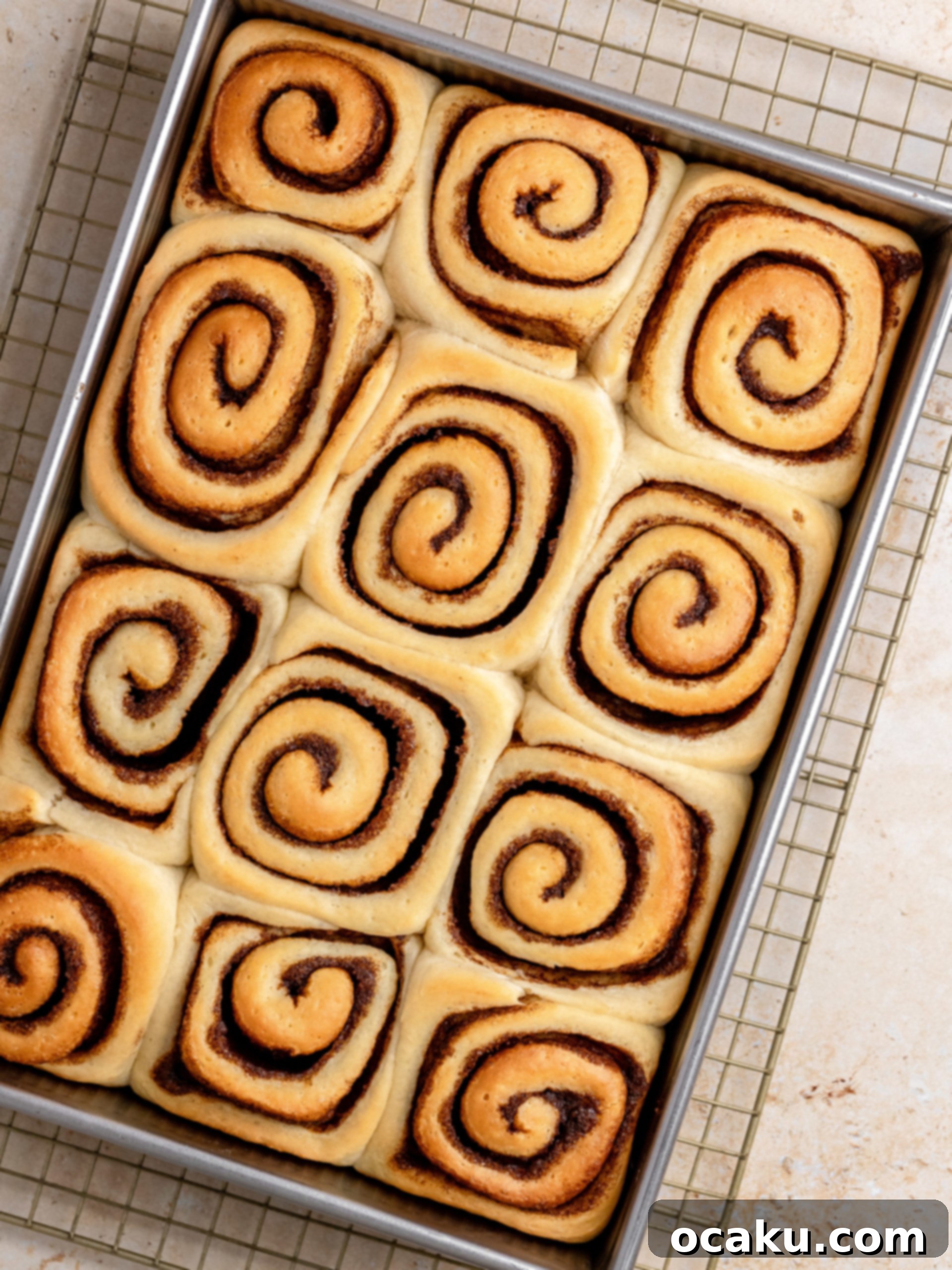 Freshly baked caramel cinnamon rolls cooling on a wire rack.