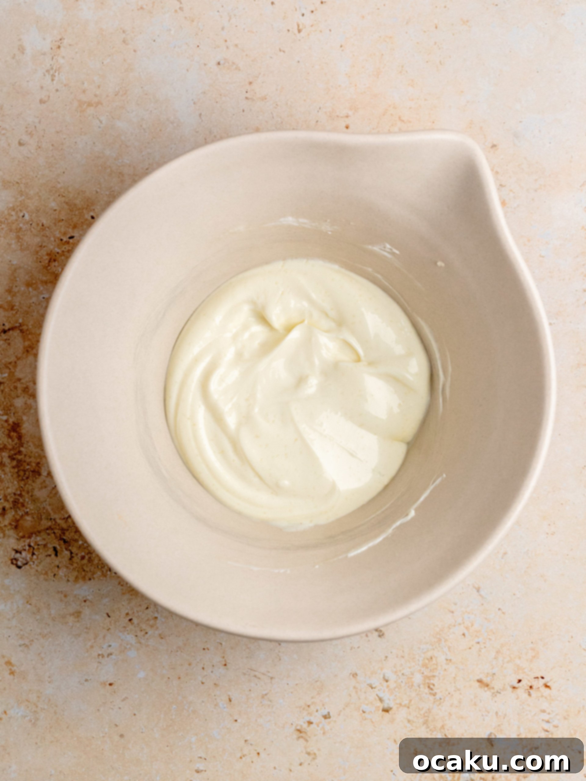 Melted butter cooling in a mixing bowl.