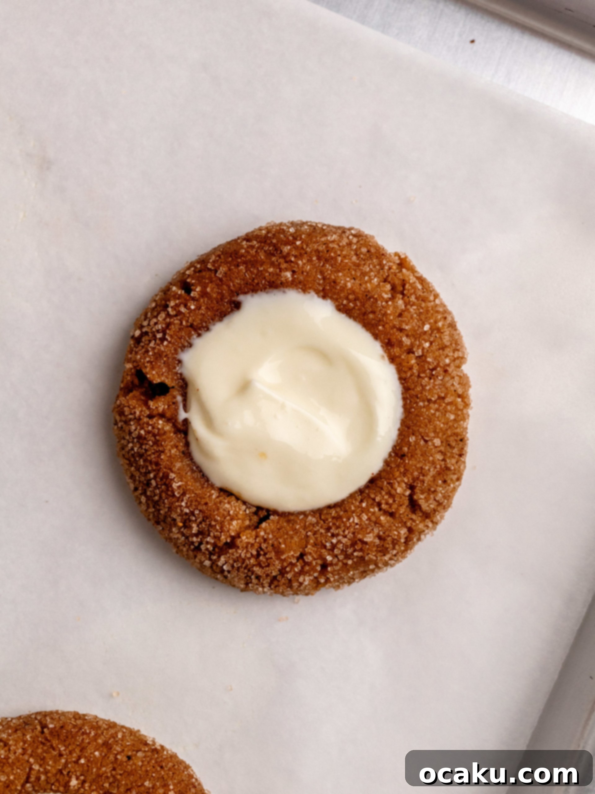 Freshly baked pumpkin cheesecake cookies on a baking sheet, with slightly browned edges.