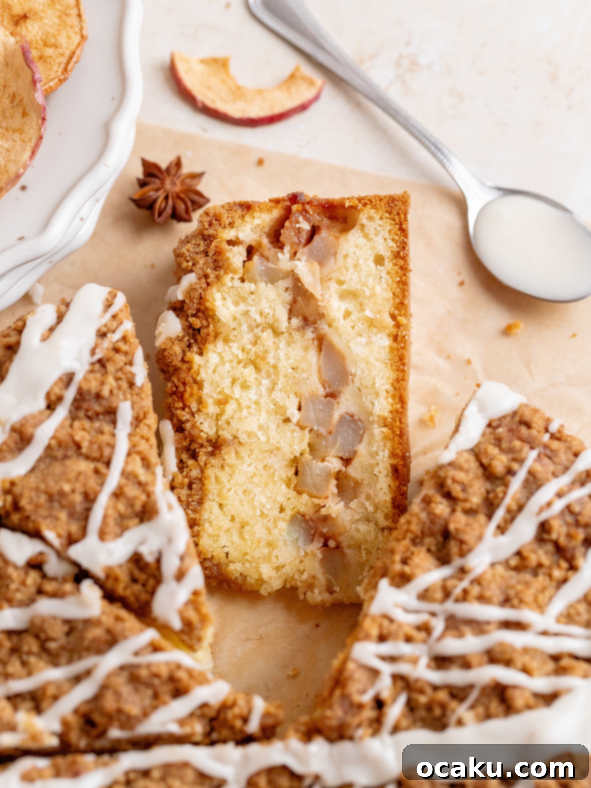 Close-up of a slice of Apple Crumb Cake, revealing the moist cake, tender cinnamon apples, and crunchy crumb topping.