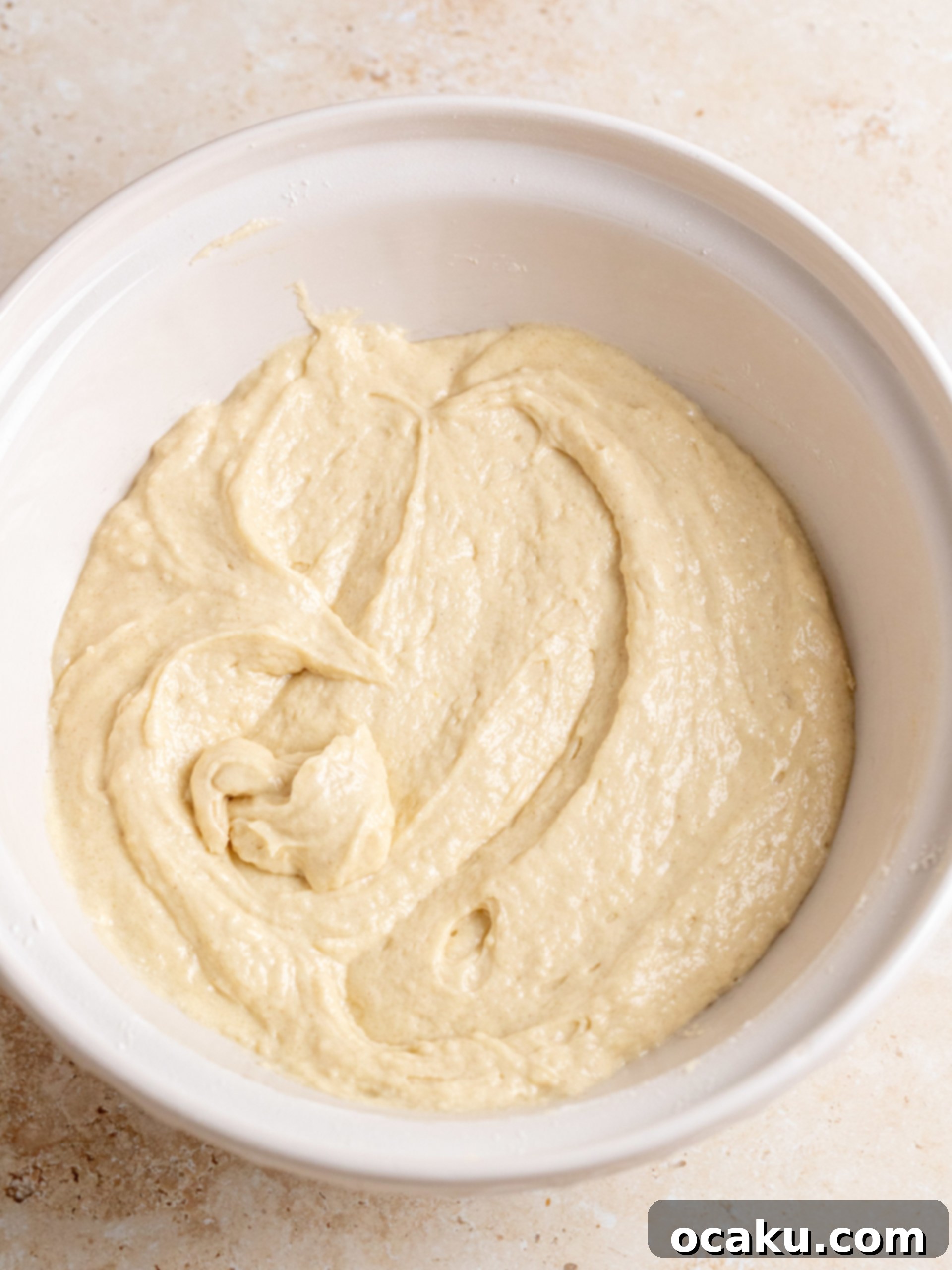 Close-up of butter and granulated sugar being creamed together in a stand mixer bowl.