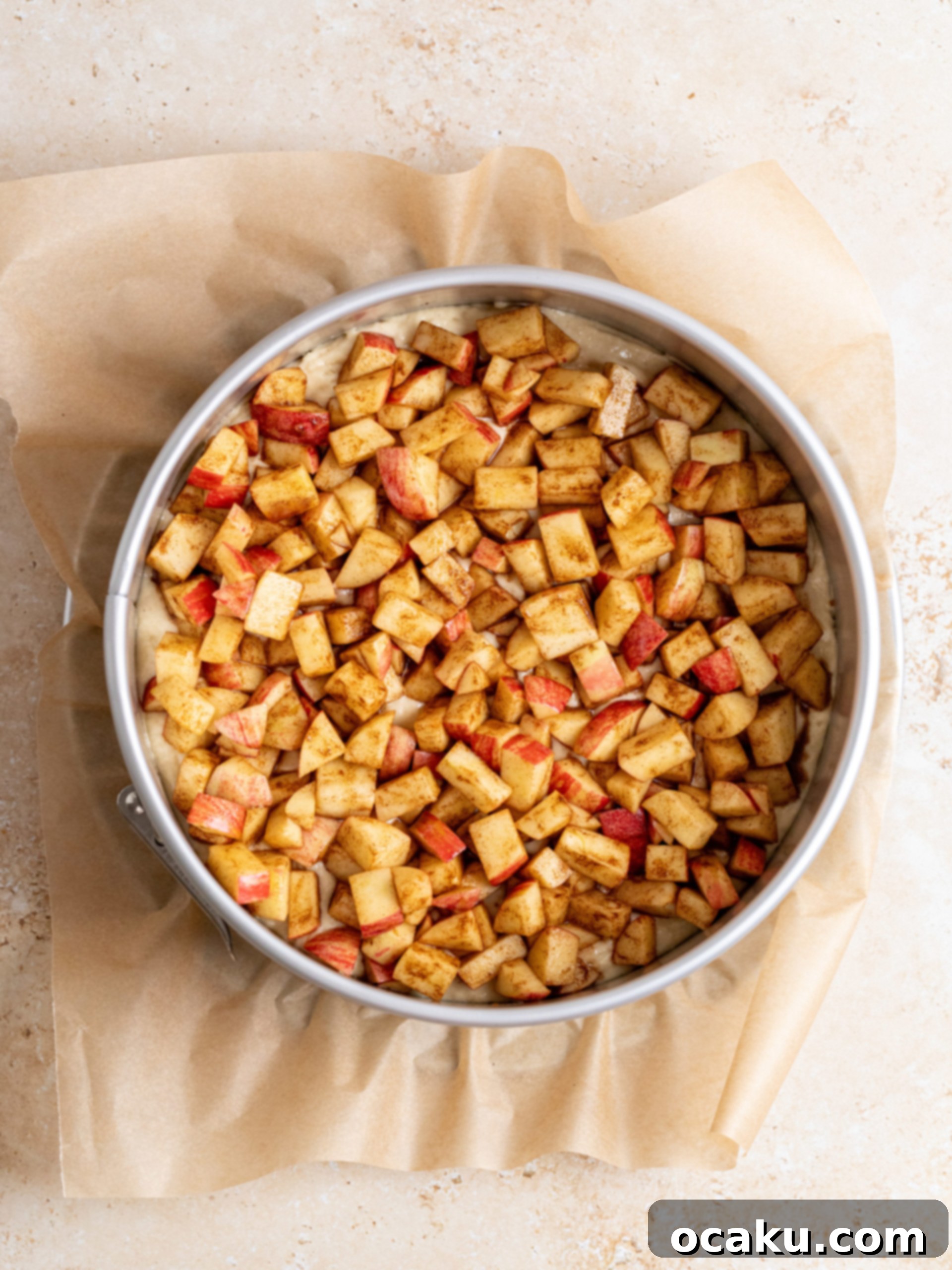 Layering the spiced cinnamon apples evenly over the first layer of cake batter.