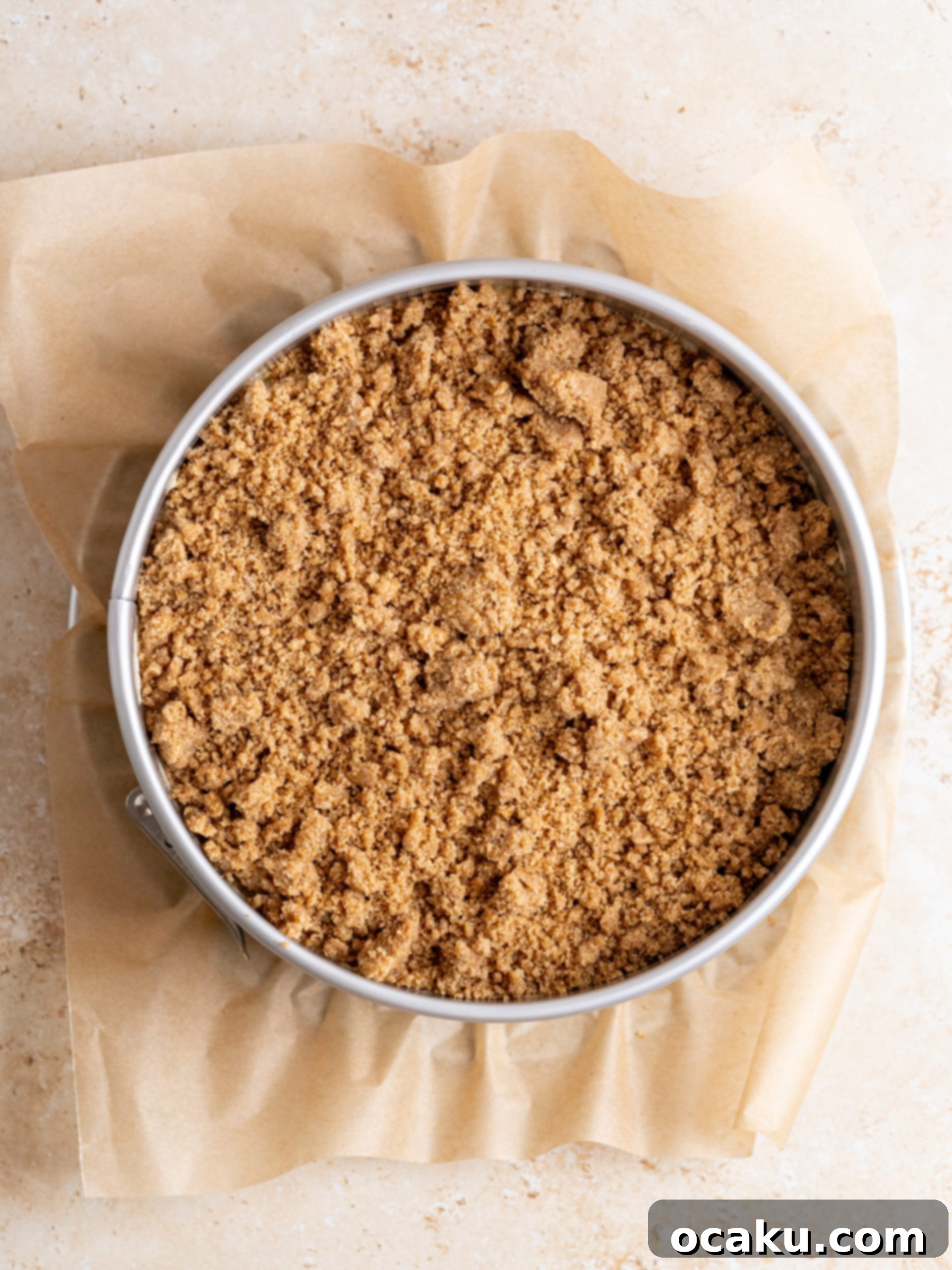 Adding the second half of the cake batter carefully over the apple layer.