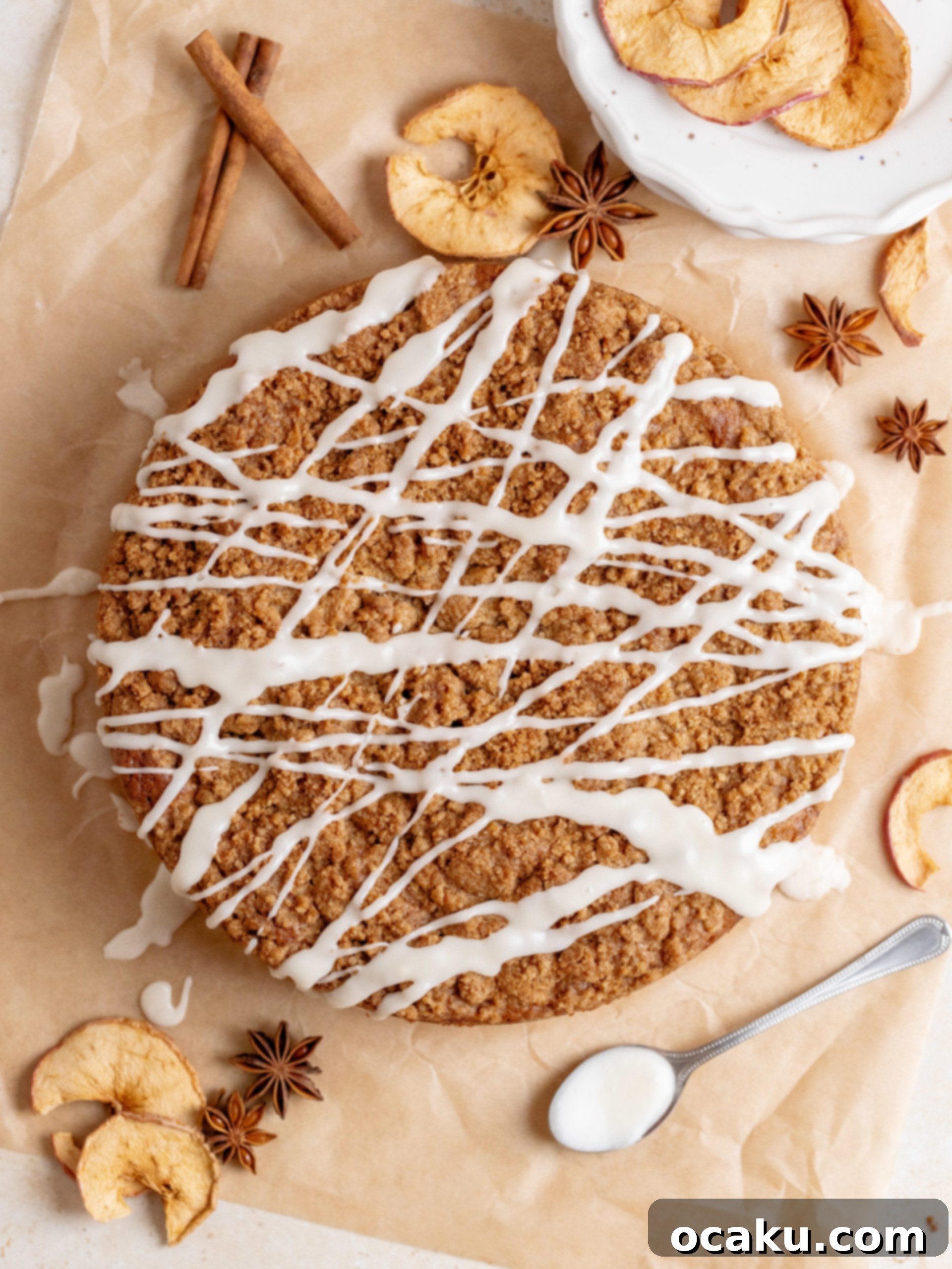 Generously sprinkling the buttery streusel crumb topping over the assembled cake layers before baking.