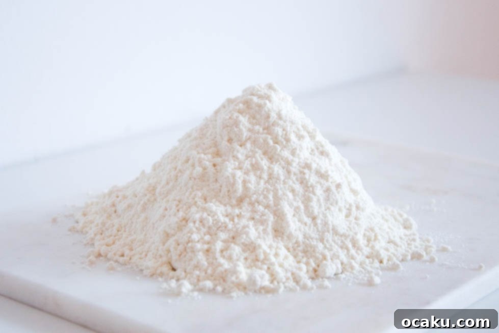 Understanding Flour Types 2 A close-up shot of various types of flour in bowls with measuring spoons, suggesting baking preparation and flour selection.