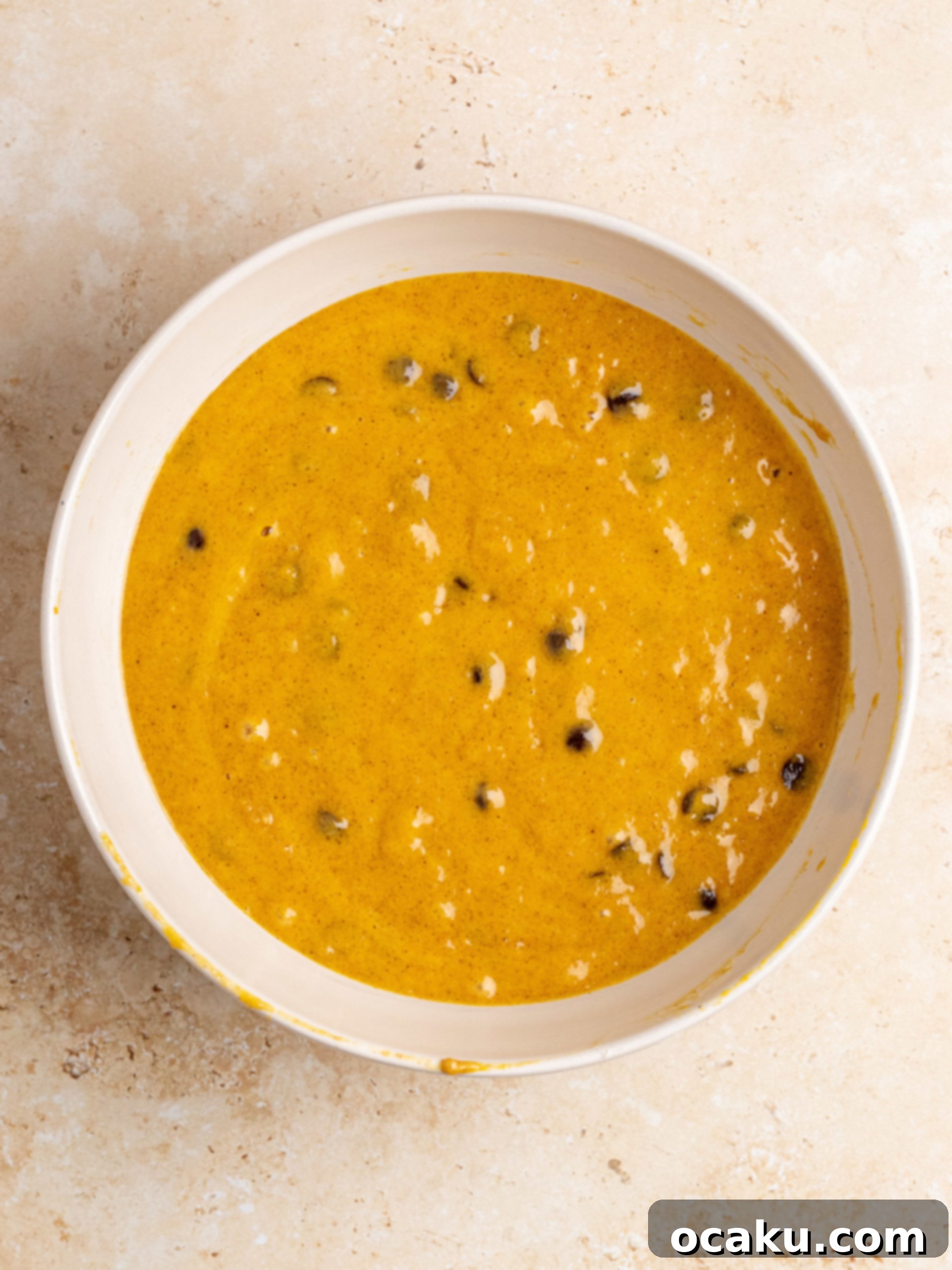 Pumpkin chocolate chip bread batter in a loaf pan, ready for baking.