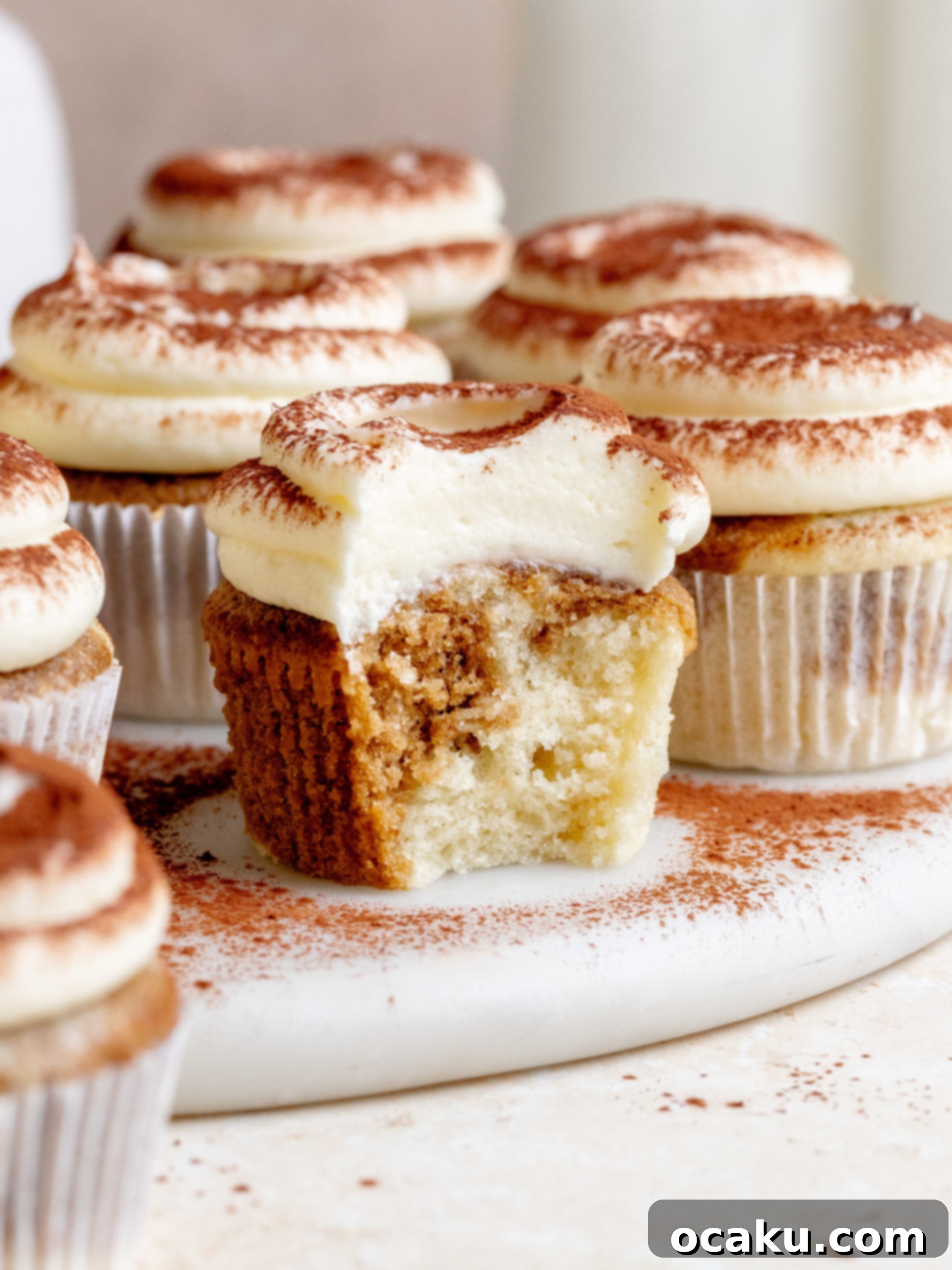 Tiramisu Cupcakes topped with fluffy Amaretto mascarpone buttercream, dusted with cocoa powder.