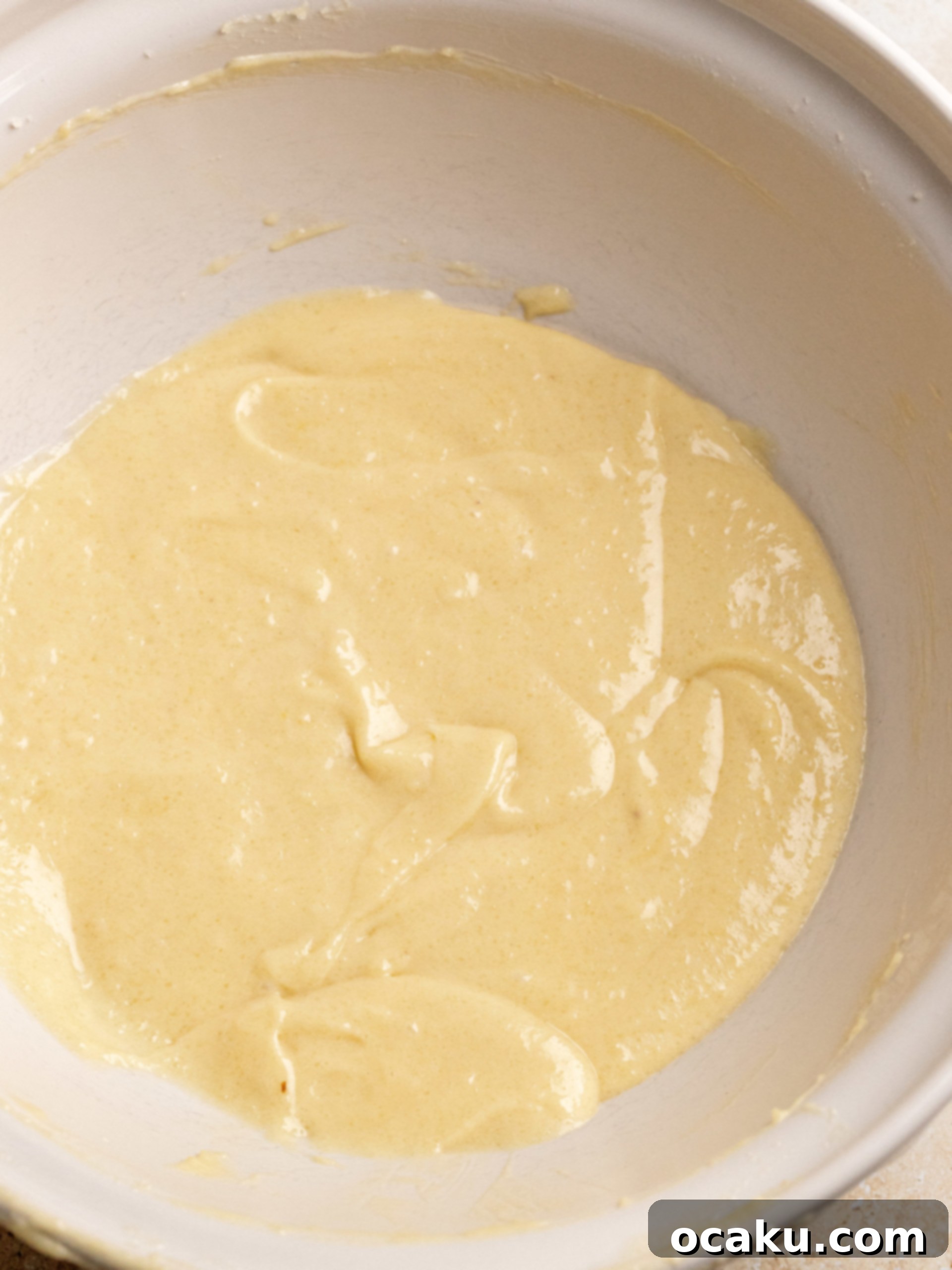 Tiramisu cupcake batter swirled with espresso in cupcake liners before baking.