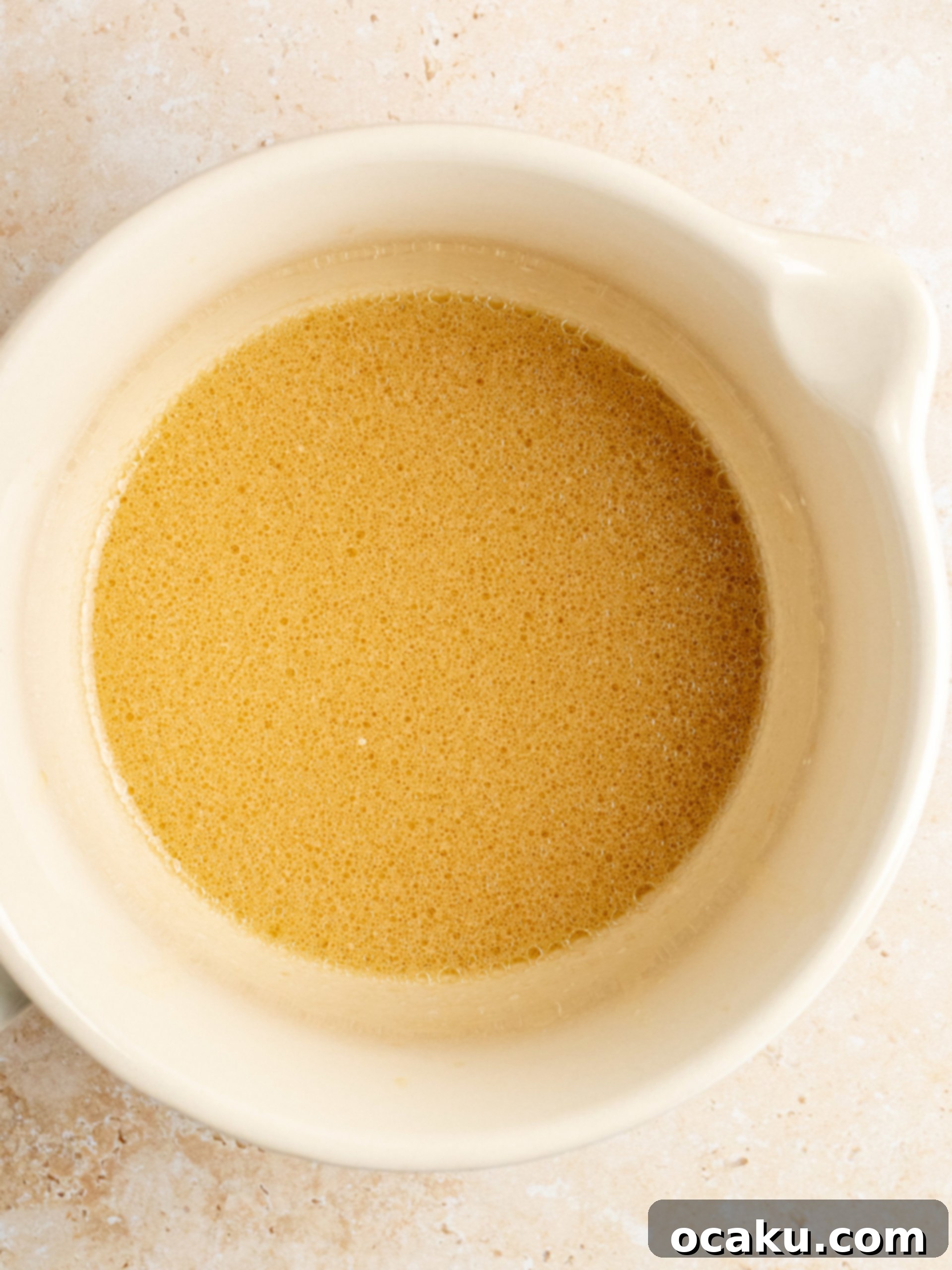 Wet ingredients for chocolate cake whisked in a separate bowl.