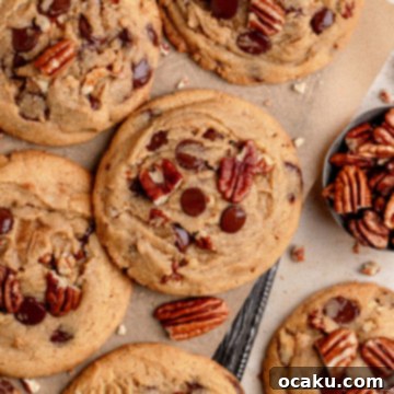 Decadent Chocolate Pecan Cookies 11 Close-up of a stack of large, golden-brown chocolate chip pecan cookies.