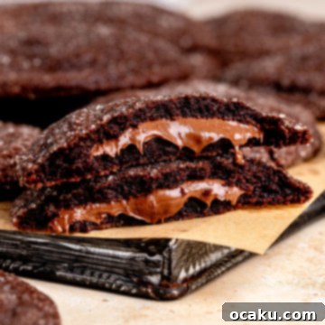 A close-up of a perfectly baked Nutella Stuffed Cookie, showing its soft interior and gooey Nutella filling.