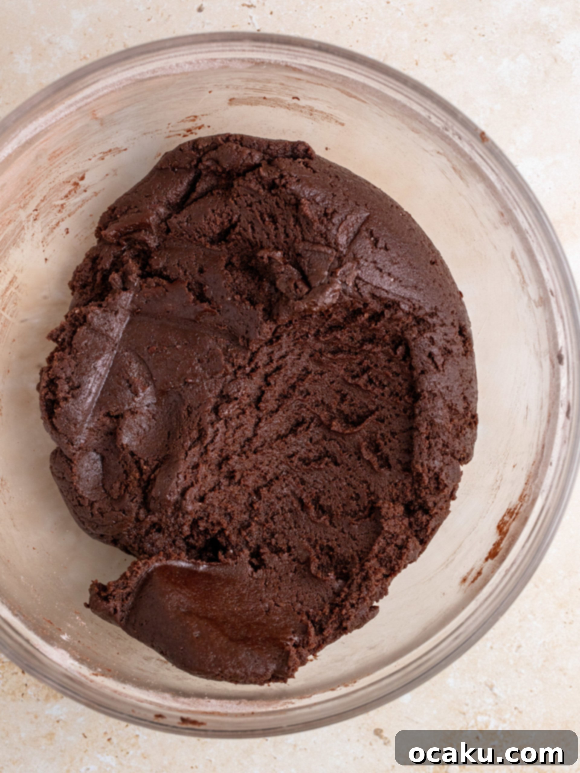 Dry ingredients (flour, cocoa powder, baking soda, salt) being mixed in a separate bowl before being added to the wet mixture.