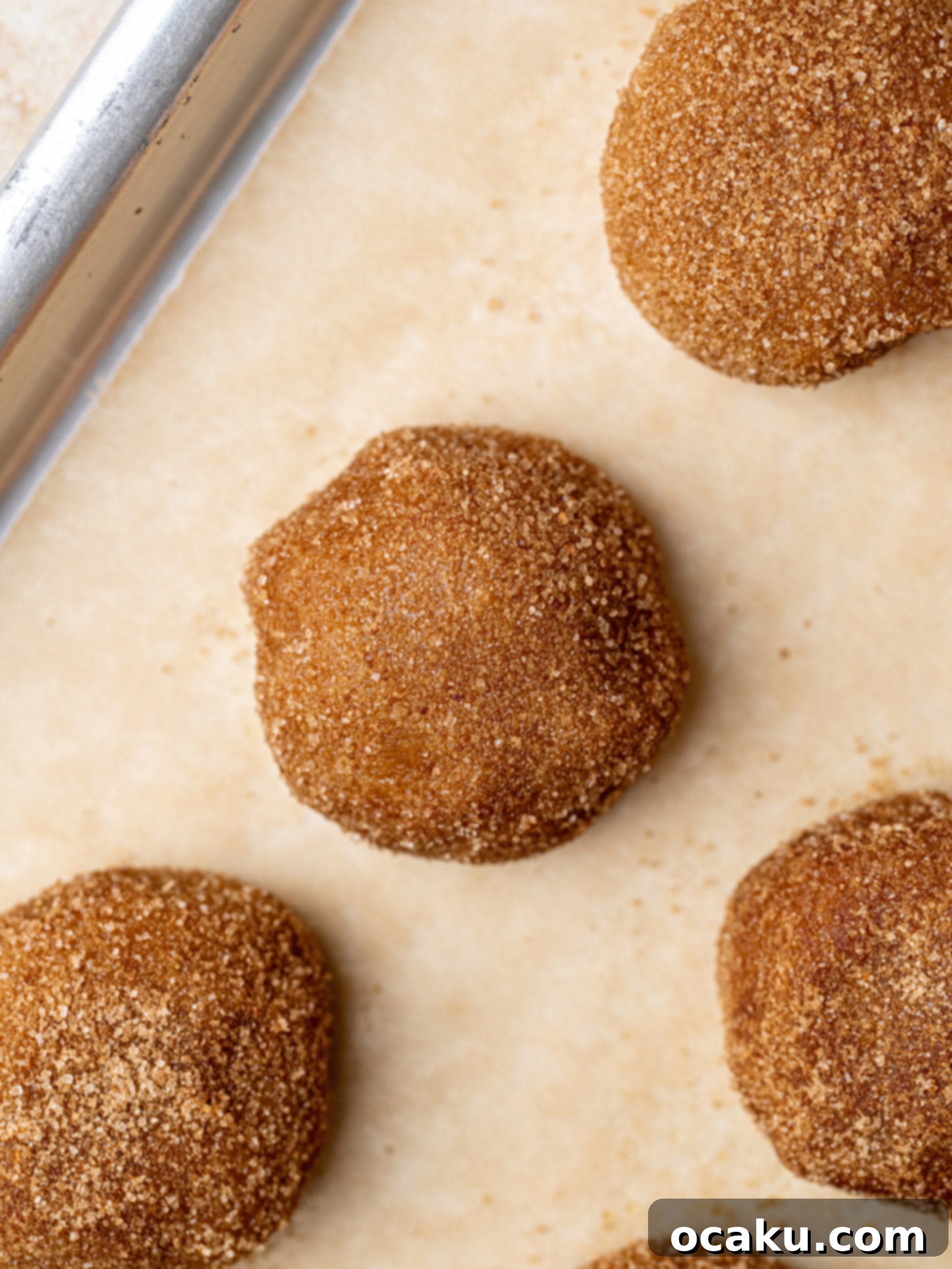 Chilled cookie dough balls arranged on a baking sheet lined with parchment paper.