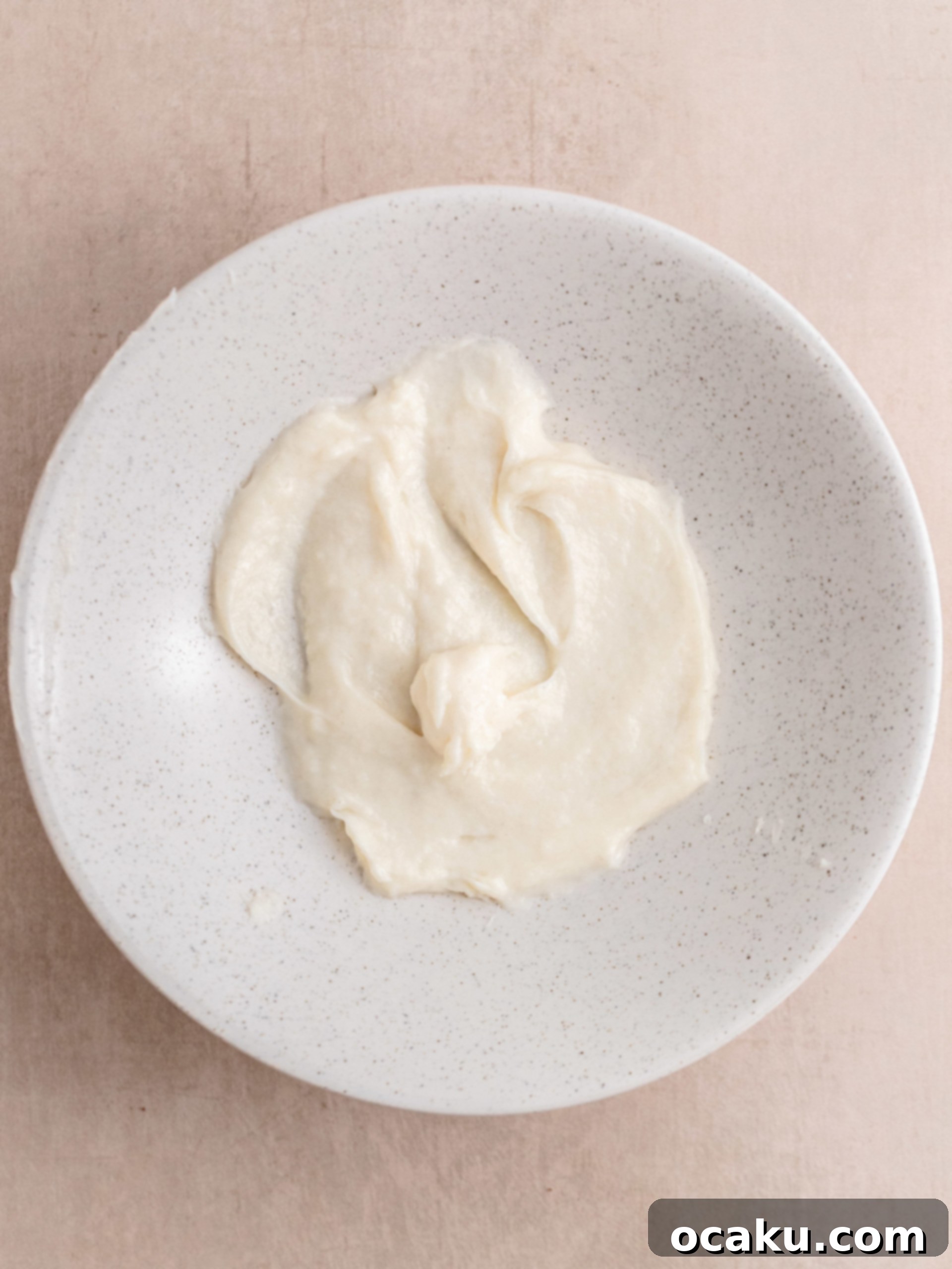 Yeast dissolving in lukewarm milk in a stand mixer bowl
