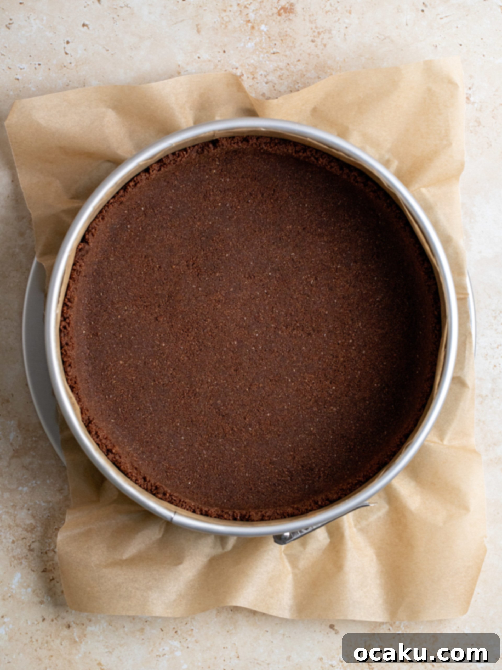 Tiramisu Cheesecake Indulgence 3 Cookie crumbs being pressed into a springform pan for the crust.