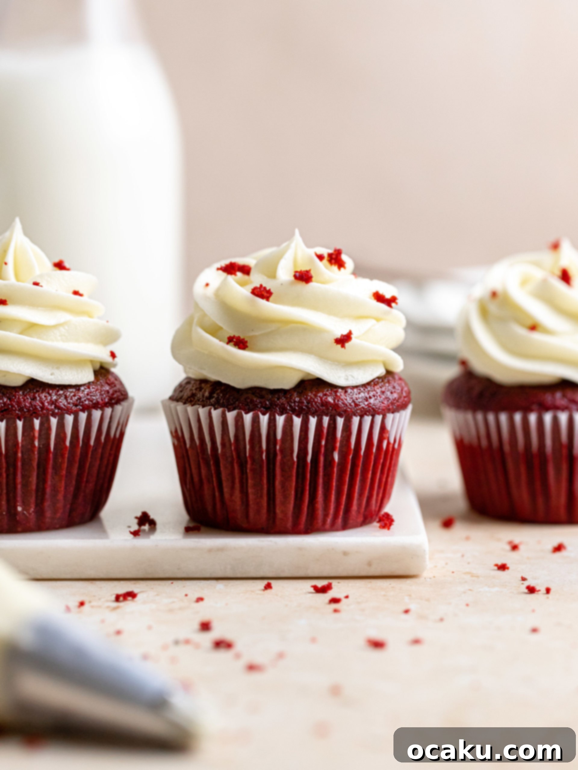 A row of perfectly baked red velvet cupcakes cooling on a wire rack